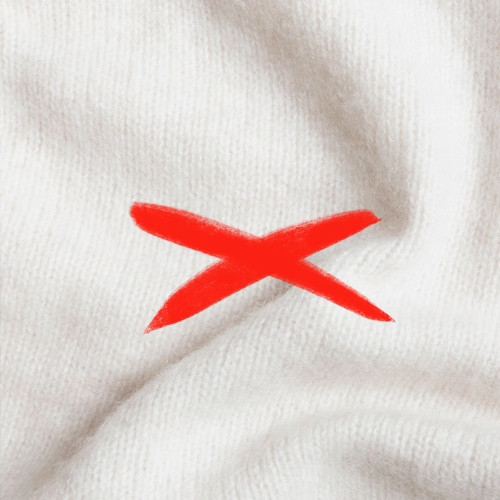 Matière laine avec une croix rouge dessus pour illuster qu'il ne faut pas porter de matière qui peuvent démanger le tatouage 